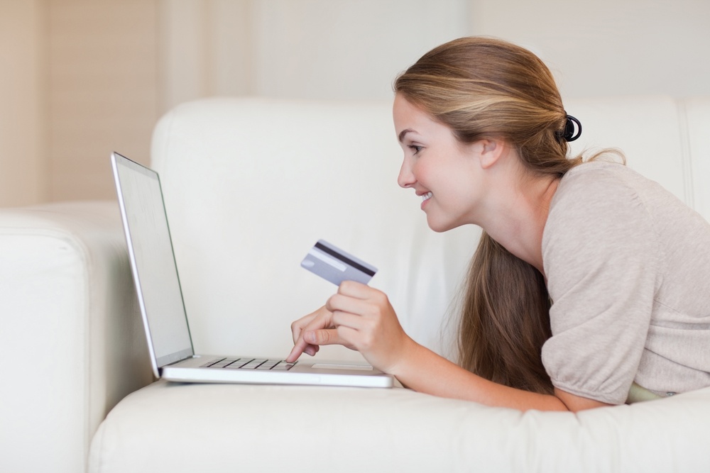 Side view of young woman on the sofa shopping online.jpeg